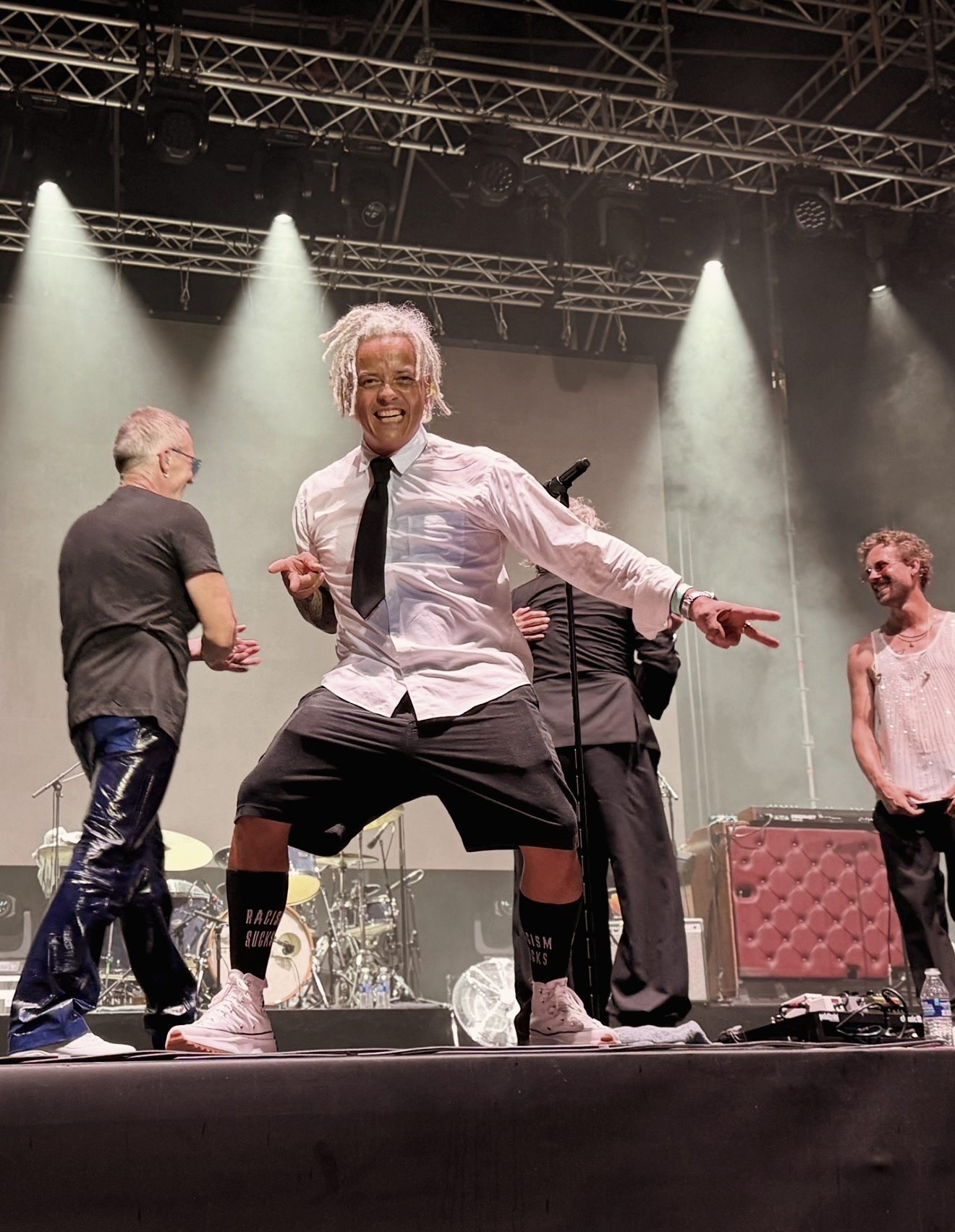 Artist på scenen i hvid skjorte og sort slips